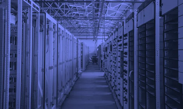 Rows of massive server racks in a modern data center glowing with LED lights