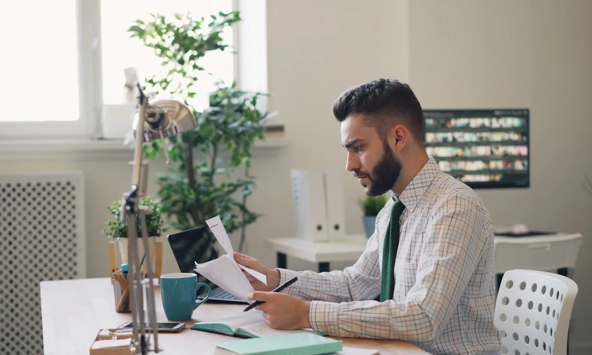 Office worker analyzing digital documents on a laptop screen.