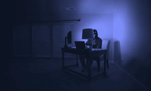 A hacker typing on a computer keyboard in the dark, representing cyber threats