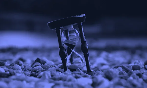 An hourglass running out of sand on a dark background