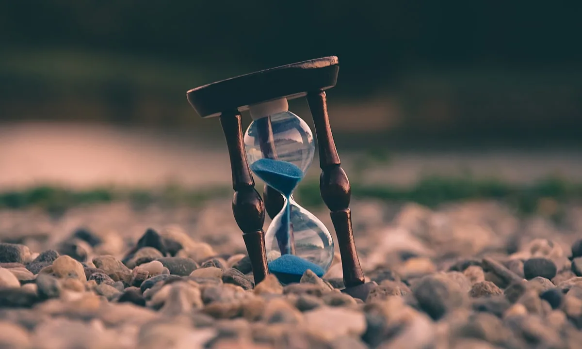 An hourglass running out of sand on a dark background
