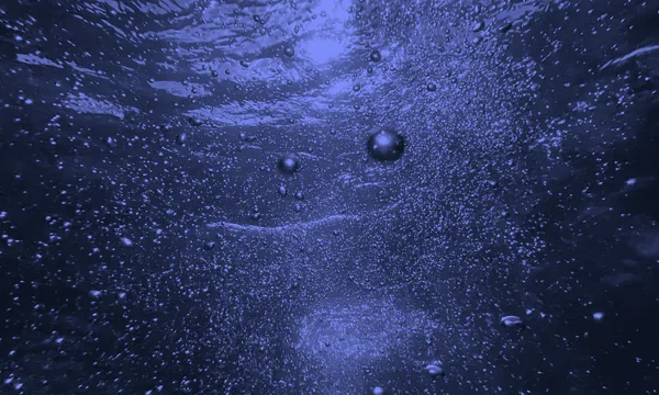 Air bubbles expanding and bursting underwater, resembling cavitation.