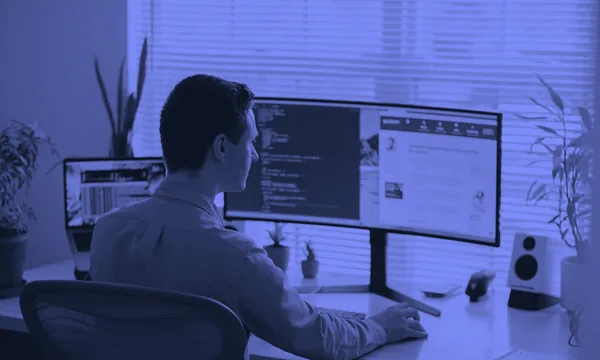 A developer reviewing code on a monitor in a quiet workspace