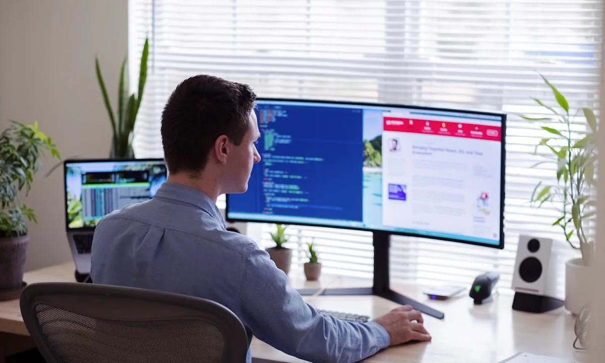 A developer reviewing code on a monitor in a quiet workspace