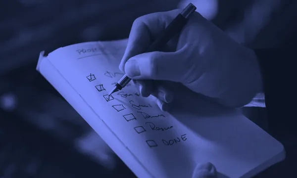 A person crossing out items on a written task list