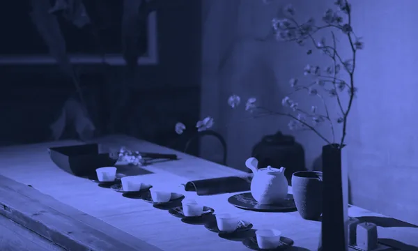 A solitary ceramic tea cup sitting on a mossy stone table