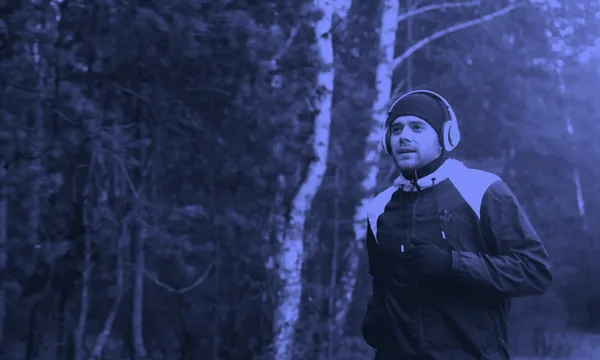 A person walking outdoors while listening to an audiobook