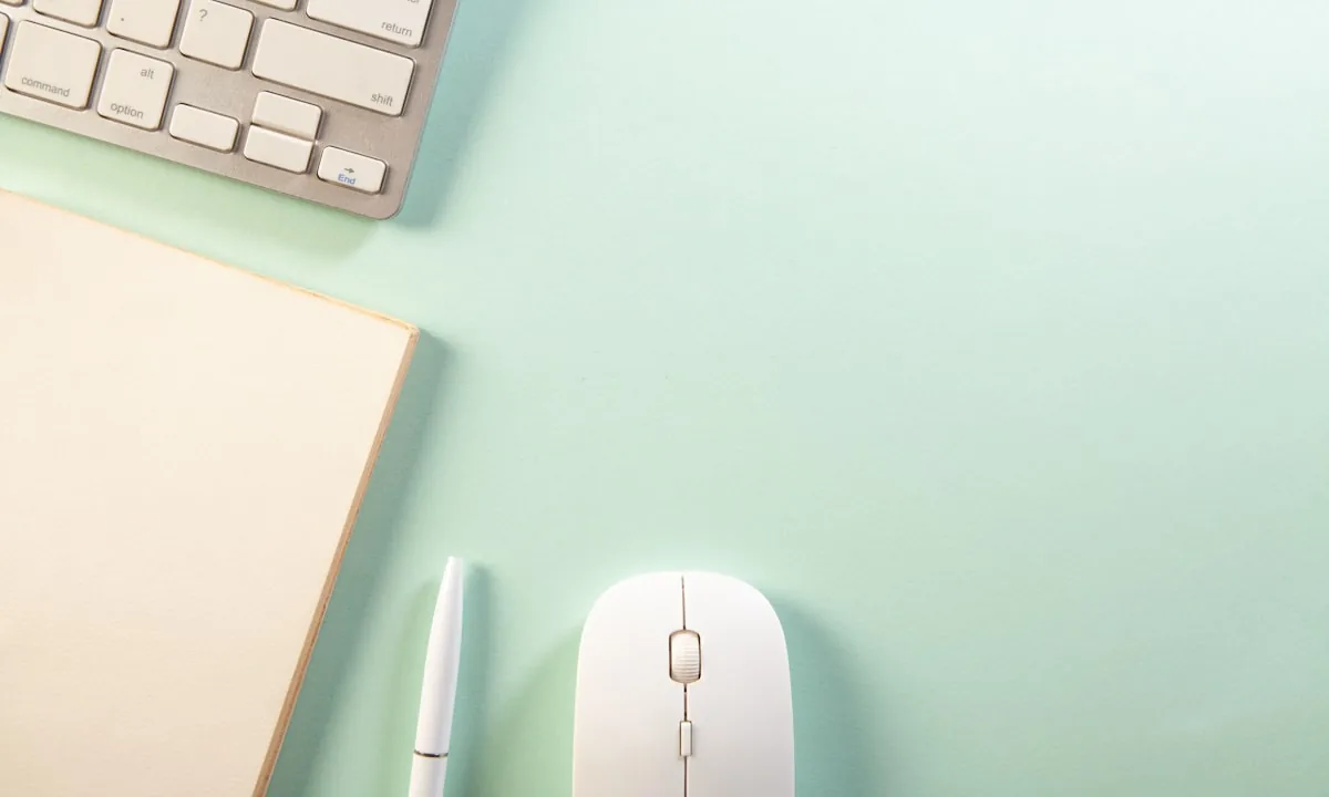 A minimalist white notebook with a pen on a clean desk