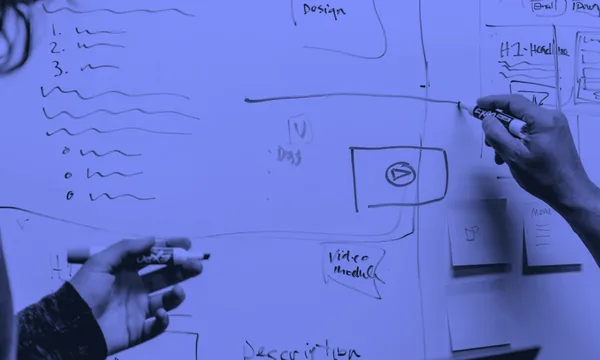 Engineering team discussing software architecture on whiteboard