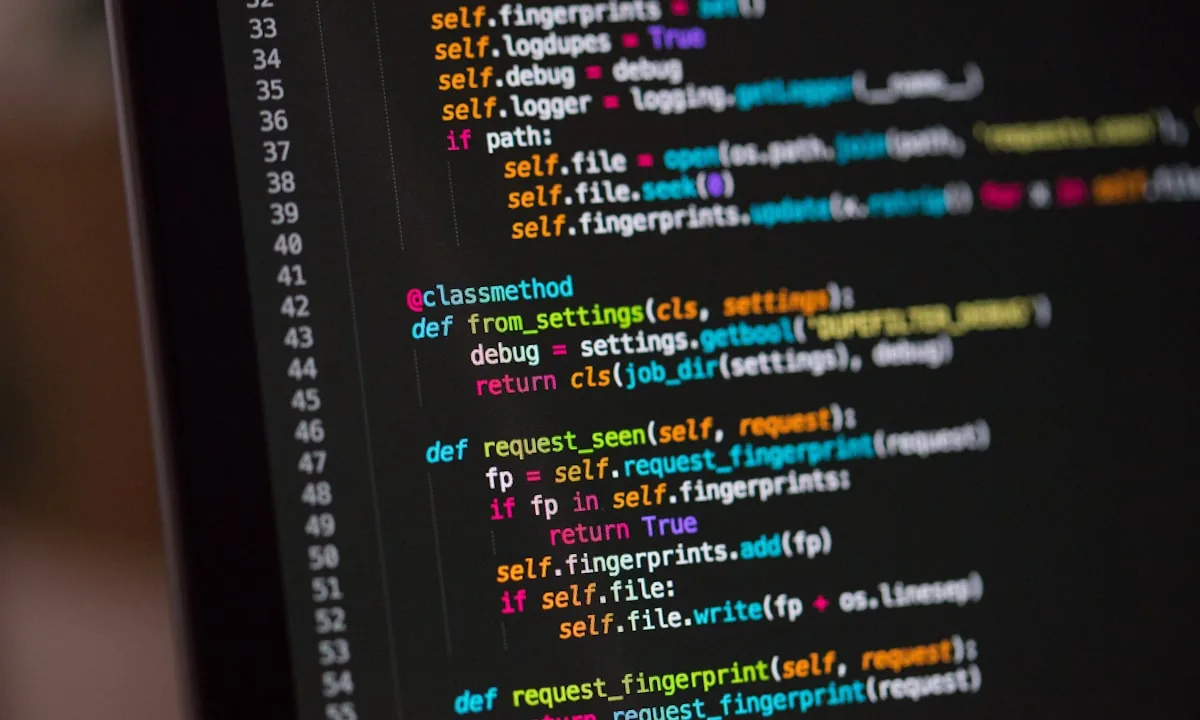 Developer reviewing code on dual monitors